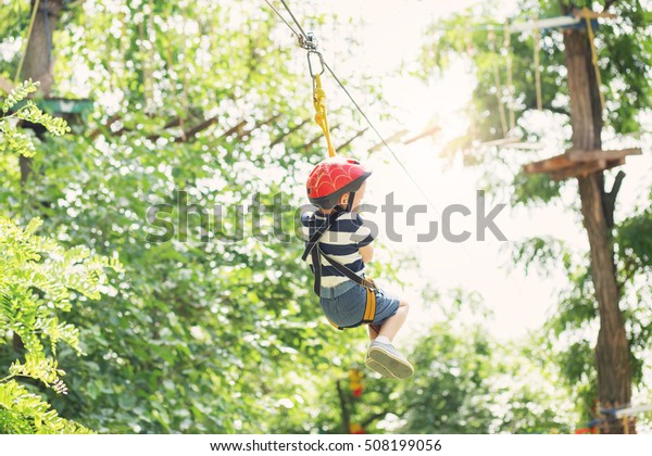 Boy enjoys\
climbing in the ropes course\
adventure.