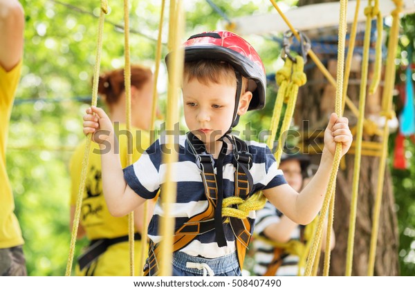 Boy
enjoys climbing in the ropes course adventure.
