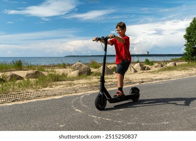 A boy enjoys riding his scooter by the lake under a clear blue sky - Powered by Shutterstock