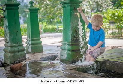 boy escapes from the heat on the street. Summer in the City residents open pump room with water in high summer to provide kids & some adults, a way to escape the oppressive heat & humidity.