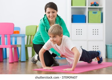 Boy exercising on foam mattress with happy physiotherapist - Powered by Shutterstock