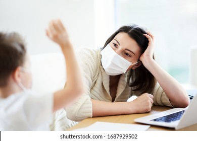Boy and exhausted mother trying to work at home during coronavirus pandemic - Shutterstock ID 1687929502