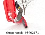 Boy falling with sleigh in the snow.