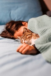 Boy Falls Asleep And Hugs His Cat, Who Sleeps With Him Under The Covers. Children And Pets. The Cat Sleeps With The Baby. The Child Is Getting Ready For Bed.