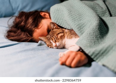 boy falls asleep and hugs his cat, who sleeps with him under the covers. children and pets. the cat sleeps with the baby. the child is getting ready for bed. - Powered by Shutterstock