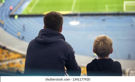 Boy with father sitting tribune at empty stadium, football fans on excursion - Powered by Shutterstock