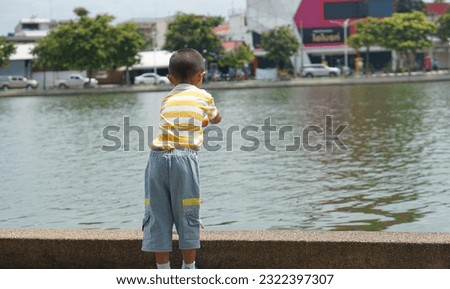 boy feeding fish in garden