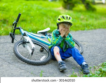 boy fell from the bike in a park.