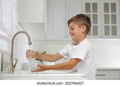 Boy filling glass with water from tap in kitchen - Powered by Shutterstock