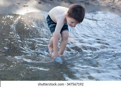 Boy Filling Water Bottle From River