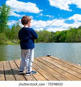 Boy Fishing From Dock On Lake.