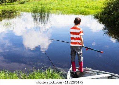 Boy With The Fishing Rod Standing On The Boat. Child Fishing Alone