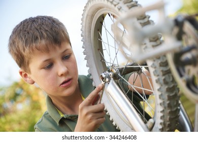 Boy Fixing Wheel Of Bike