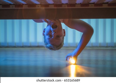 The Boy With A Flashlight Look Under Bed. Night Time