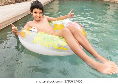 Boy floating on an inflatable circle in the pool. A child in the pool