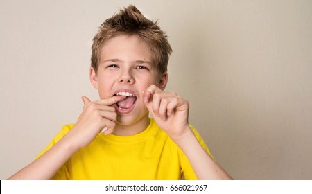 Boy Flossing Teeth. Close-up Portrait Of Teen Boy With Dental Floss Isolated.