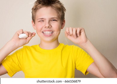 Boy Flossing Teeth. Close-up Portrait Of Teen Boy With Dental Floss Isolated.