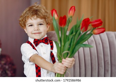 Boy with flowers. Gentelman with tulip. Mother's day. Valentines day.