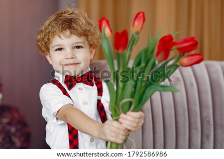 Boy with flowers. Gentelman with tulip. Mother's day. Valentines day.