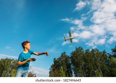 Boy Flying Remote Controlled Plane In Nature