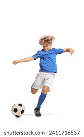 Boy in a football kit kicking a ball isolated on white background