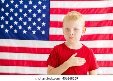 Boy in front of American flag with hand over heart