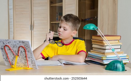 Boy With Funny Glasses Doing Homework. Child With Learning Difficulties. Boy Having Problems With His Homework. Education Concept.