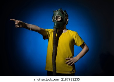 A Boy In A Gas Mask Points His Finger To The Side On A Blue Background