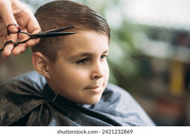 The boy getting haircut by scissor in barbershop. Barber use scissor - Powered by Shutterstock