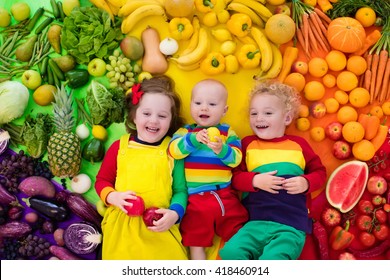 Boy, Girl And Baby With Variety Of Fruit And Vegetable. Colorful Rainbow Of Raw Fruits And Vegetables. Child Eating Healthy Snack. Vegetarian Nutrition For Kids. Vitamins For Children. View From Above