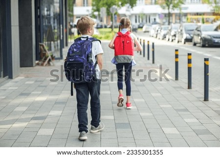 Boy and girl with backpack behind back. Back to school. Children go to school for study. Beginning of school lessons. Concept of school, study, education, friendship, childhood