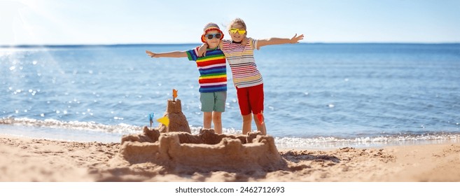 Boy and girl building on the beach sandcastle. Family vacation and tourism concept. - Powered by Shutterstock