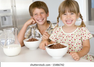 Boy And Girl Eating Breakfast Cereal At Home