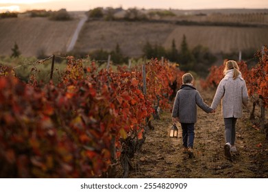 A boy and a girl embrace in a red vineyard during autumn, surrounded by vibrant fall foliage. The warm light from the lantern they hold adds a magical touch to the serene, peaceful moment - Powered by Shutterstock