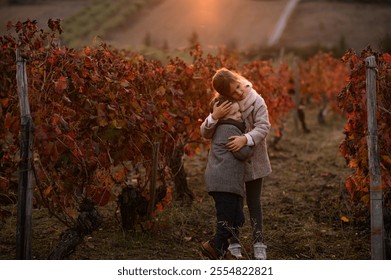 A boy and a girl embrace in a red vineyard during autumn, surrounded by the vibrant colors of fall. The warm hues of the foliage create a cozy, intimate atmosphere as they share a tender
 - Powered by Shutterstock