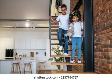 Boy And Girl Going Down Stairs At Home