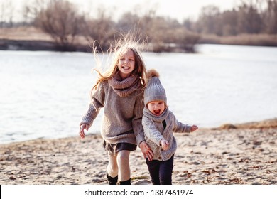 A Boy And A Girl  Having Fun Outside In Early Spring In The Forest Near The Water. A Sister And Brothe Together. Friendship And  Family Concept