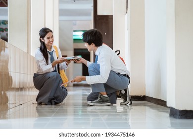 A Boy And A Girl In High School Uniform Pick Up The Book Fell On The Floor Together