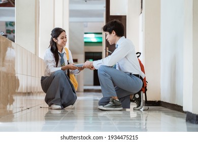 A Boy And A Girl In High School Uniform Pick Up The Book Fell On The Floor Together