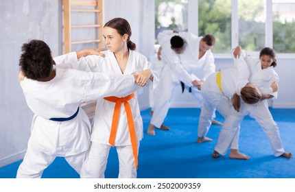 Boy and girl judokas train judo in group in studio.. - Powered by Shutterstock