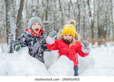 Boy And Girl Laughing In Snow Forest.