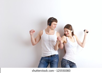 boy and girl  listening of a music and dancing on wall background - Powered by Shutterstock