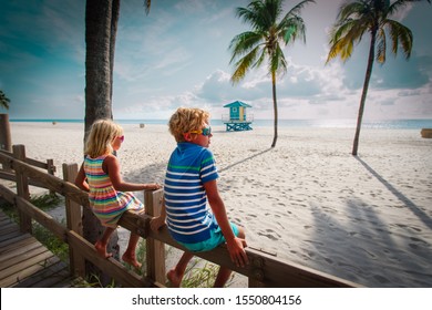 Boy And Girl Looking At Tropical Beach With Palms, Family On Vacation In Florida