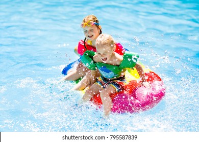 Boy And Girl On Inflatable Ice Cream Float In Outdoor Swimming Pool Of Tropical Resort. Summer Vacation With Kids. Swim Aids And Wear For Children. Water Toys. Little Child Floating On Colorful Raft.