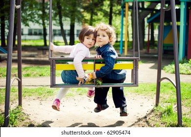 Boy And Girl On The Swings