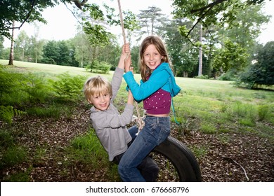 Boy And Girl On Tire Swing