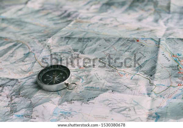 Boy and girl planning the route on a map and a\
compass over the car