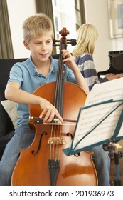 Boy And Girl Playing Cello And  Piano At Home