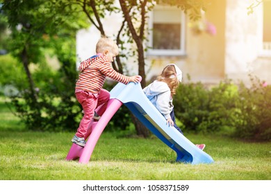 Boy and girl playing on the backyard on sliding