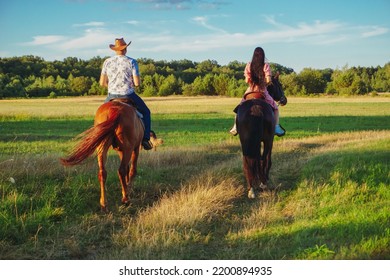 A boy and a girl riding horses in a field. Group of friends riding horses. People with their horses. Horseman. Horsewoman. A group of two young people horseback riding in the grassy fields. - Powered by Shutterstock